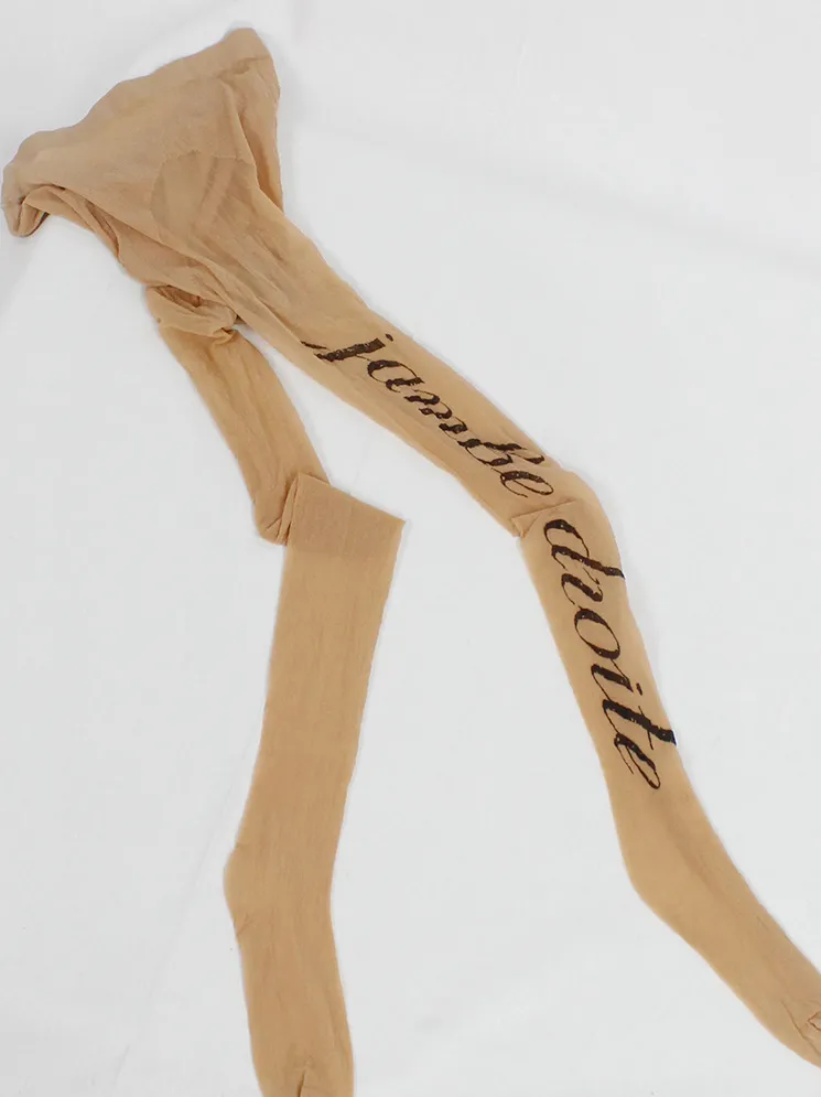 Ann Demeulemeester ecru tattoo pantyhose with cursive “Jambe Droite” lettering — spring 1998